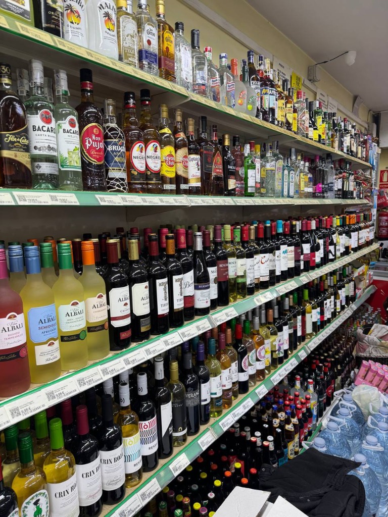 Estantes de supermercado con etiquetas de precios impresas para botellas de alcohol